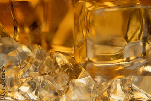 Whiskey with ice background close -up. Macro shot of whiskey and ice.