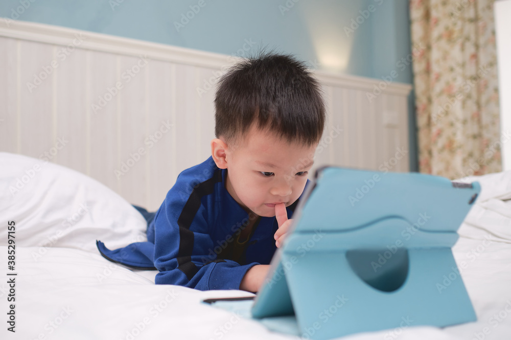 Cute Asian 3 - 4 years old toddler boy child playing game, watching cartoon, using tablet pc computer, Gadget addicted children, Learning Tablet for Kids Cute Asian 3 - 4 years old toddler boy child playing game, watching cartoon, using tablet pc computer, Gadget addicted children, Learning Tablet for Kids