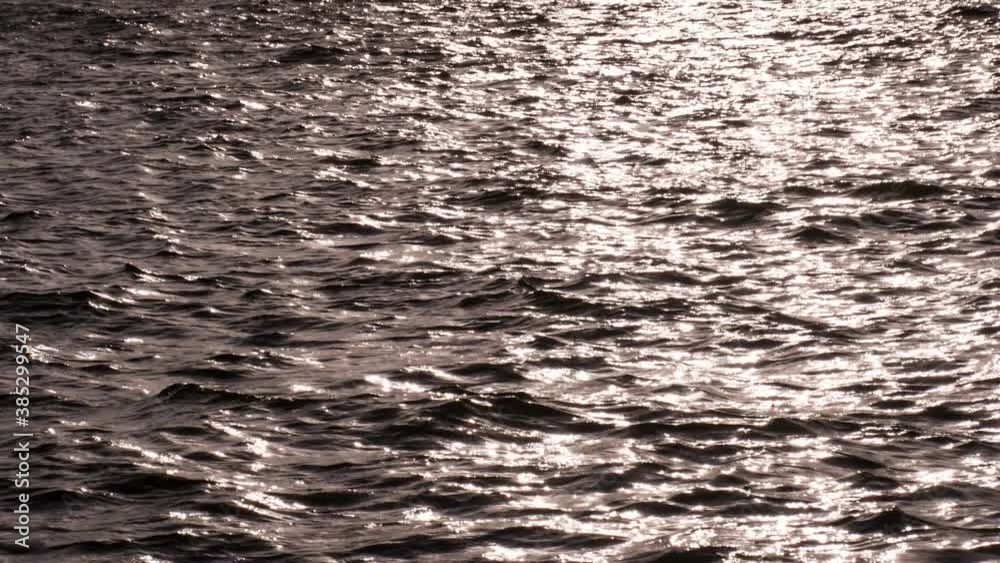 Slow Northern Waves at Sunset. Bronze sea waves at sunset light. Slow Motion