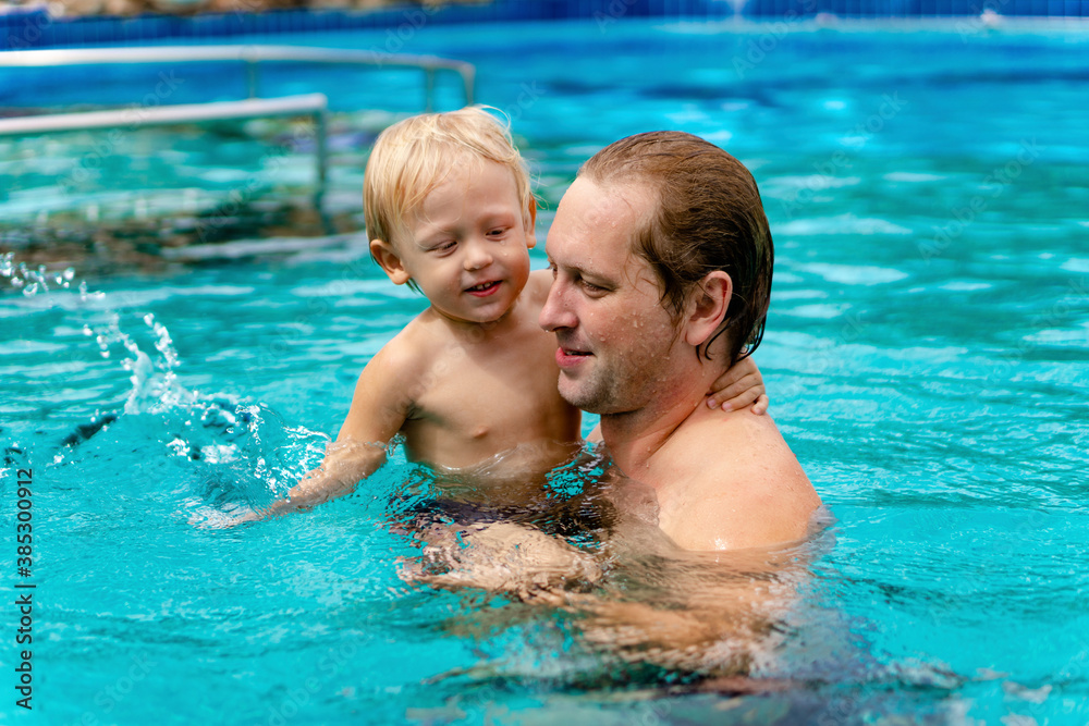 Dad and son swim in the pool