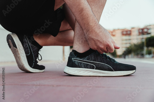 Man's hands tying their shoelaces before running