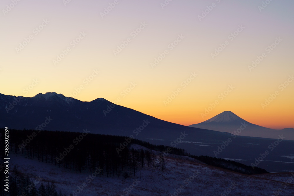 The silhouette of Mt. Fuji that emerges in the orange sunrise sky