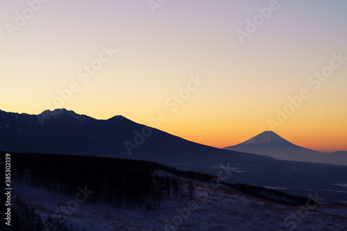 The silhouette of Mt. Fuji that emerges in the orange sunrise sky