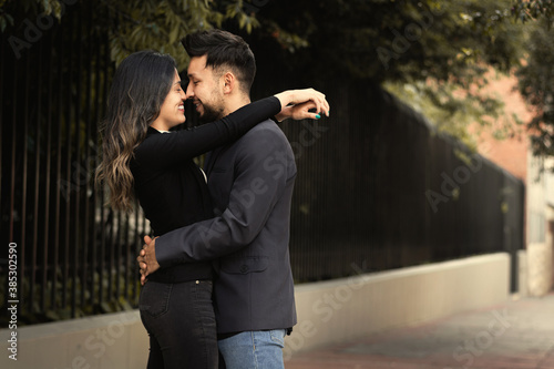 pareja de novios abrazados mirandose frente a frente en una calle del centro de bogota photo