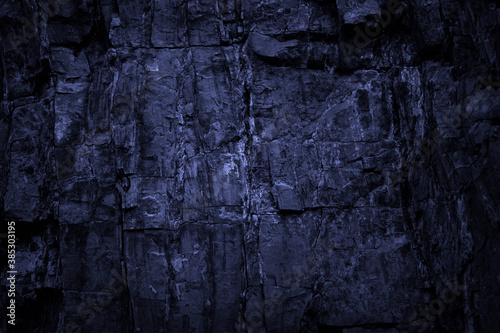 Toned stone texture. Black blue rock background. Detail. Dark grunge background with light effect.