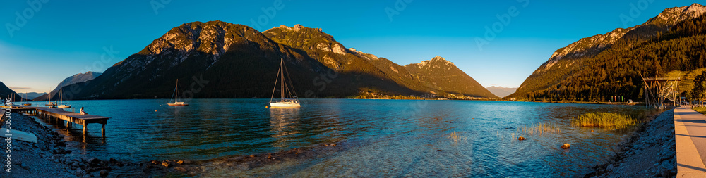High resolution stitched panorama of a beautiful alpine sunset view with boats at the famous Achensee, Pertisau, Tyrol, Austria