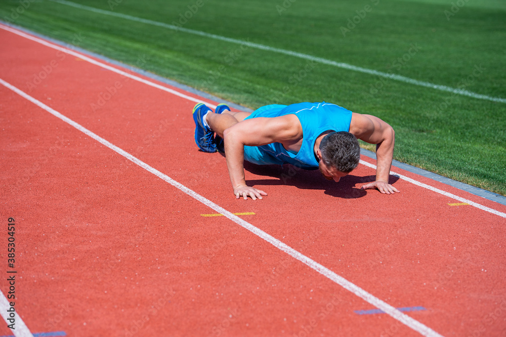 muscular man stand in plank making push up on sport training, success