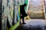 Silhouette man standing against graffiti in the shadows