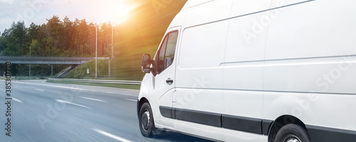 White modern delivery small shipment cargo courier van moving fast on motorway road to city urban suburb. Busines distribution and logistics express service. Mini bus driving on highway day. banner