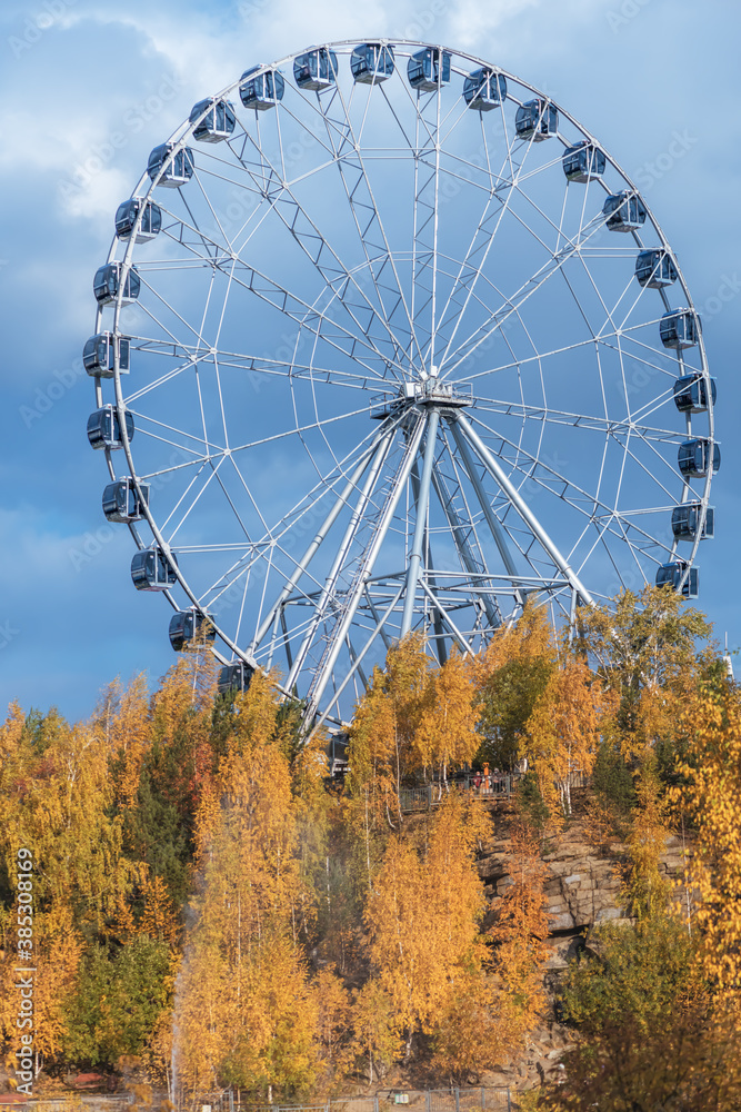 The Ferris wheel is autumn. trees with yellow leaves. The Ferris wheel is autumn. trees with yellow leaves.