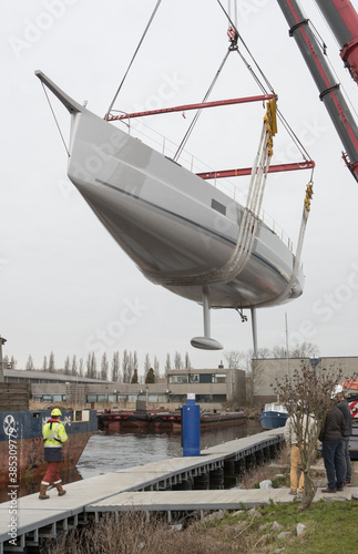 Launch of a super sailing yacht. Lifting and hoisting with cranes. Shipbuilding industry.