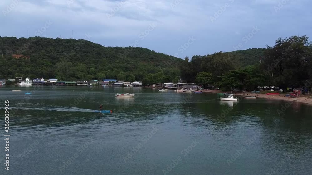 Local man on paddle board at SE Asian island fishing village Local man on paddle board at SE Asian island fishing village
