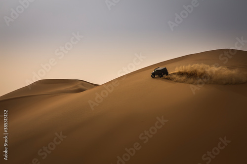 car driving in Rub al Khali Desert at the Empty Quarter, in Abu Dhabi, UAE