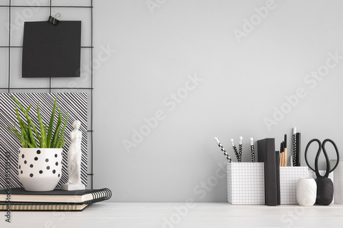 Home office desk with supplies,memoboard and grey wall mockup. photo