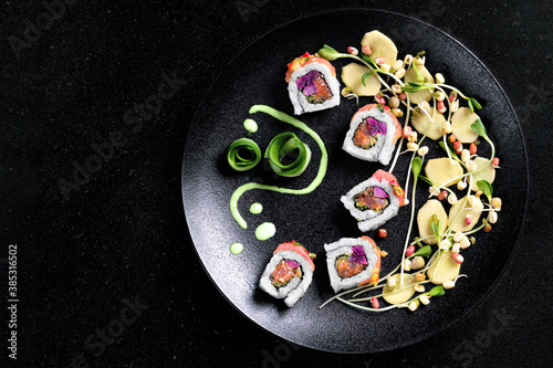 Sushi rolls set served on black plate on dark background.Design concept.Top view