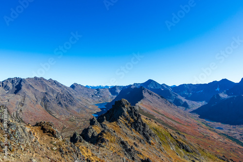 Wide angle panoramic view from the summit of Wolverine Peak, Chugach Mountains, Alaska. The photo was taken in autumn, when the tundra has autumn colors. The ridge separates two glacial valleys.
