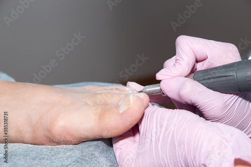 Sanding the client s toenails. The process of hardware pedicure.
