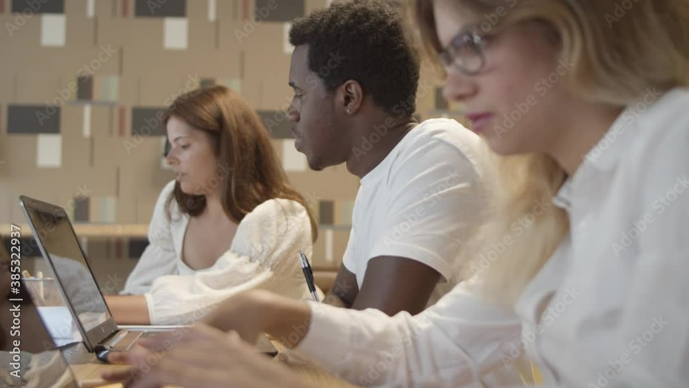 Creative team sitting at table with laptops and talking, discussing project, brainstorming. Collaboration and teamwork concept Creative team sitting at table with laptops and talking, discussing project, brainstorming. Collaboration and teamwork concept