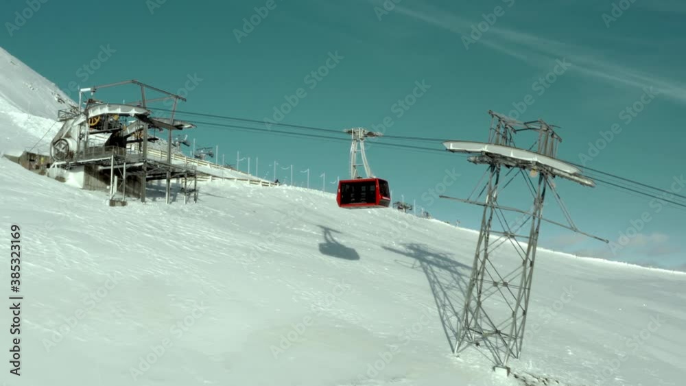 Gondola cable car tram arriving at top of mountain lift, aerial view