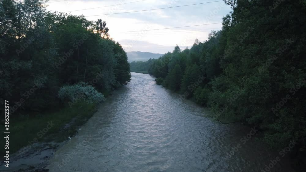 River flowing after heavy rain. Water stream After strong rain. Dirty and turbulent water after rain. Muddy river stream River flowing after heavy rain. Water stream After strong rain. Dirty and turbulent water after rain. Muddy river stream