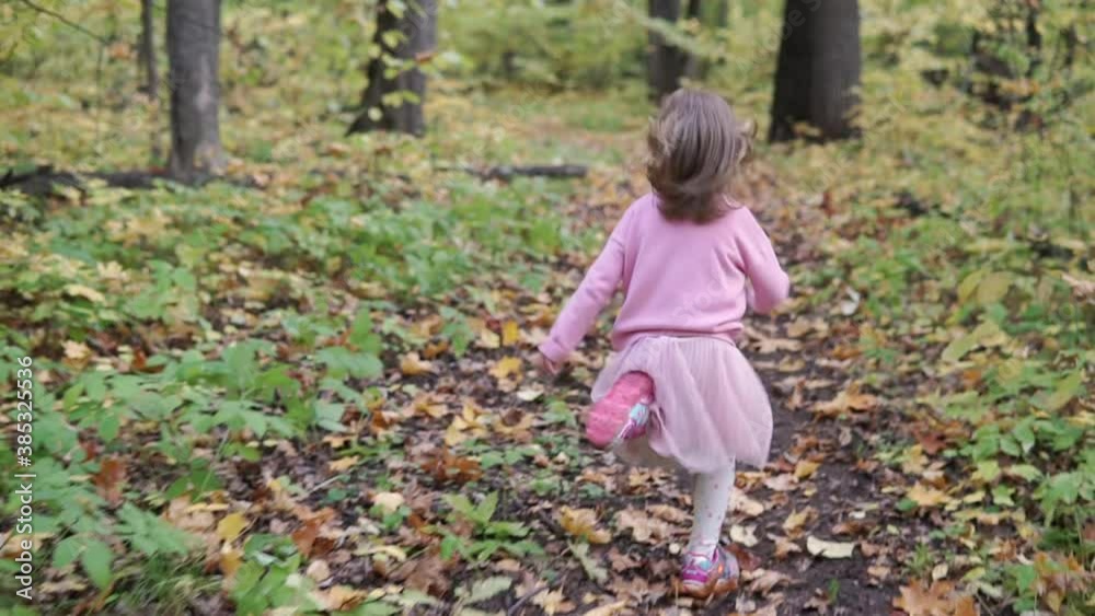 Girl in slow motion runs along the trail in the autumn forest Girl in slow motion runs along the trail in the autumn forest