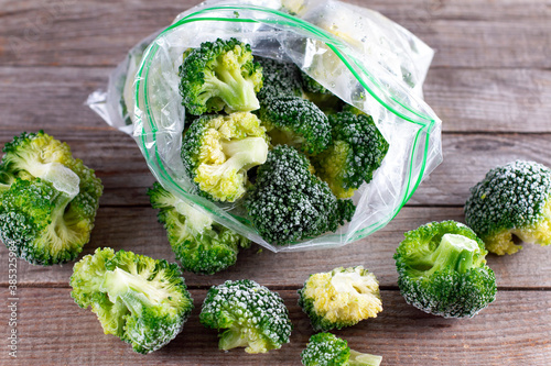 Fototapeta Naklejka Na Ścianę i Meble -  Fresh frozen broccoli in a plastic bag on wooden table