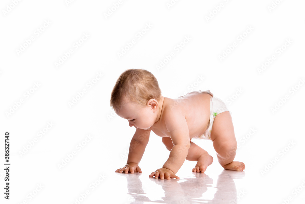 Baby in diapers crawling on white studio floor Baby in diapers crawling on white studio floor