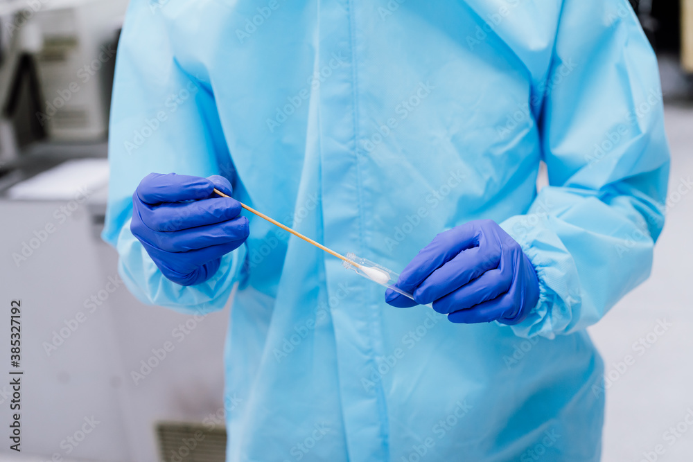 Fototapeta premium Medical scientist in PPE suit uniform holding swab coronavirus test in laboratory