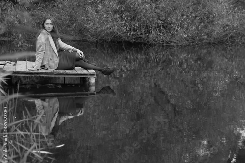 Woman sitting near the lake in black and white