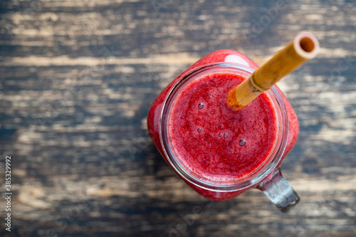 Fresh blackberry smoothie in the glass jar on wooden background. Top view, close up, copy space. Healthy food concept