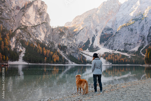 man with a dog at the famous mountain lake Braies in Italy. Traveling with a pet. High quality photo