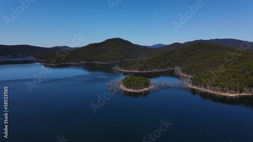 Blue Sky Over The Forested Mountains Surrounding The Calm Lake - Advancetown Lake Near Hinze Dam - Gold Coast, QLD, Australia.  - aerial drone shot photo