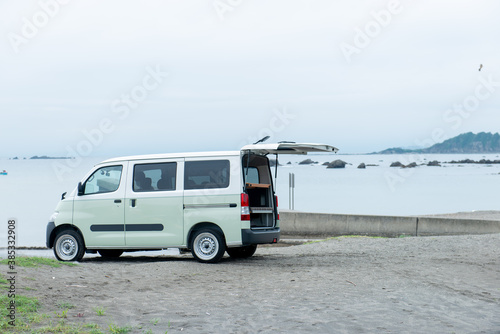海辺の砂浜に停まる軽ワゴン車