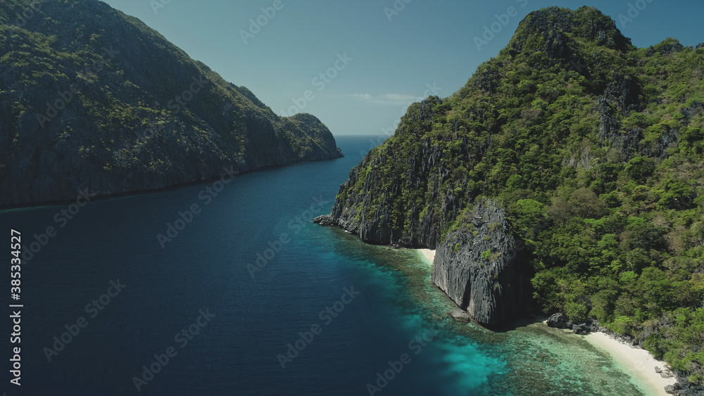 Green tropic mountain island nature at ocean bay aerial panorama view. Amazing greenery mount ranges with tropical forest and plants. Epic seascape of sea coast water at soft light drone shot