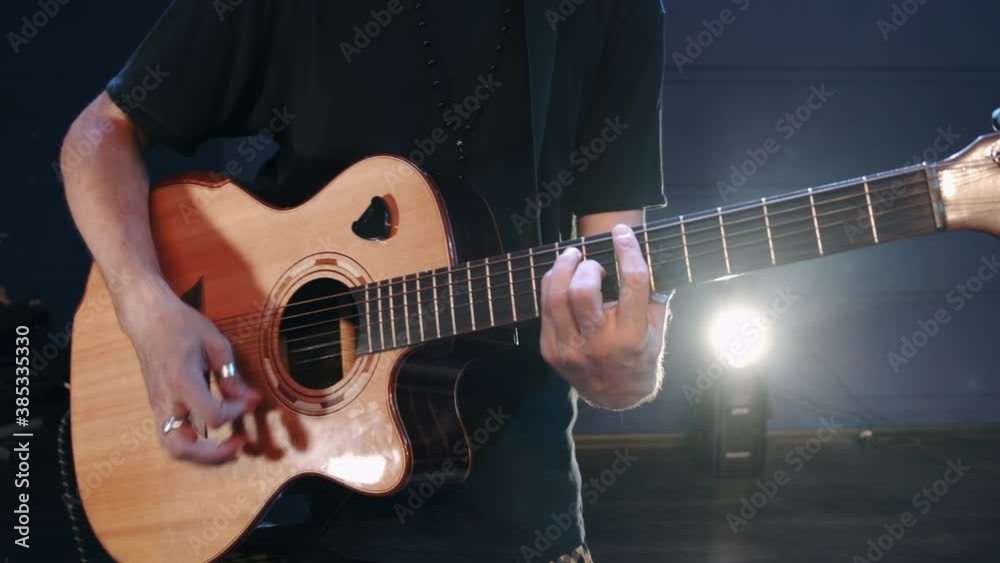 Male musician playing acoustic guitar. Guitarist plays in classical guitar on stage in concert . Rock music band . Male musician playing acoustic guitar. Guitarist plays in classical guitar on stage in concert . Rock music band .