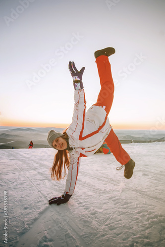 A woman doing a handstand on the top of Mountains in Sheregesh, Siberia. Winter activity, ski resort.