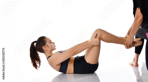 Young woman exercising with trainer studio shot
