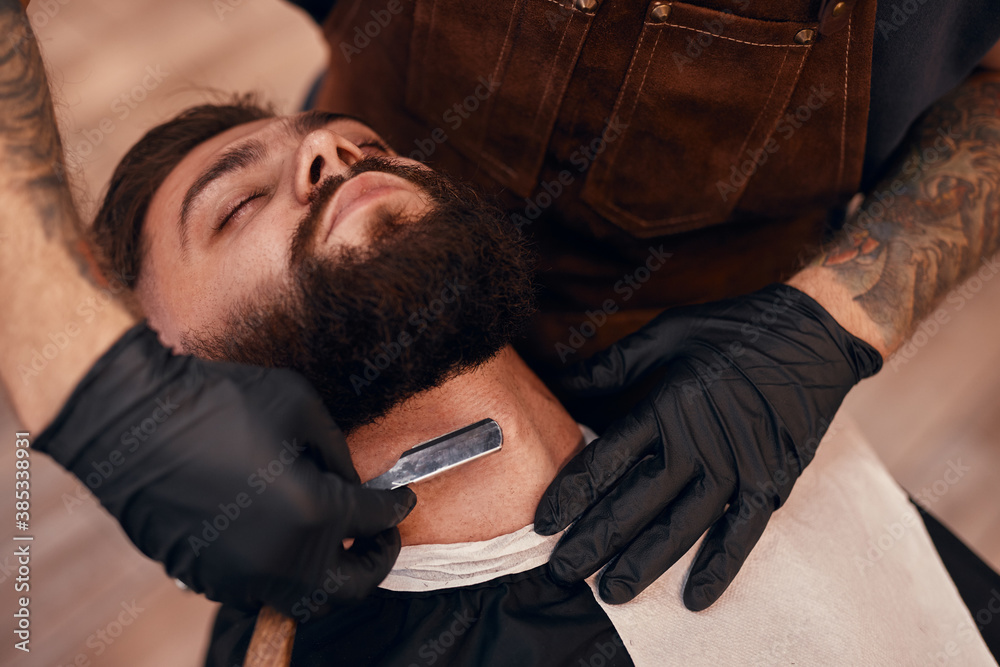 Fototapeta premium Crop barber shaving neck of customer