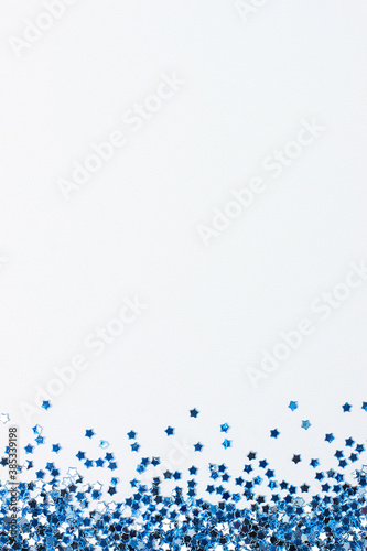 Blue confetti on white. Colorful Christmas or holiday background
