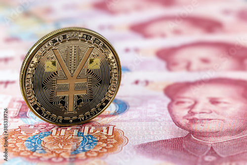 e-RMB gold coin, over 100 yuan banknotes, conceptual image of the digital version of the yuan. Chinese decentralized currency photo