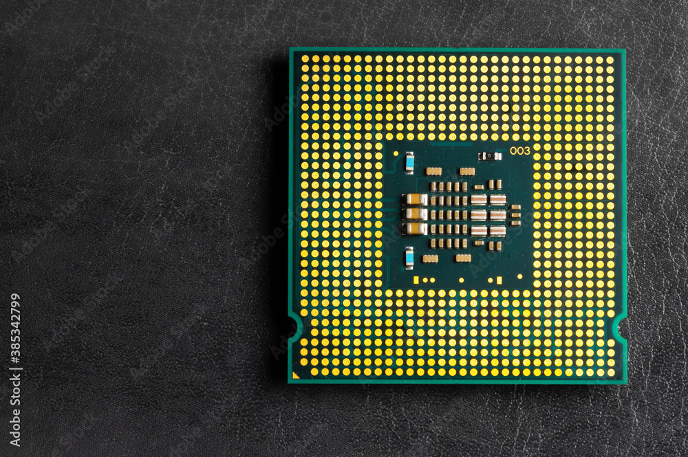 Obraz premium The microprocessor processor of the CPU of a computer or laptop lies on a dark matte surface. Close-up. Electronic and computing equipment. Macro