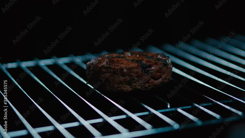 Parrilla con carne de hamburguesa con fuego de fondo. Cocinando carne de hamburguesa al grill. 240 fps HD