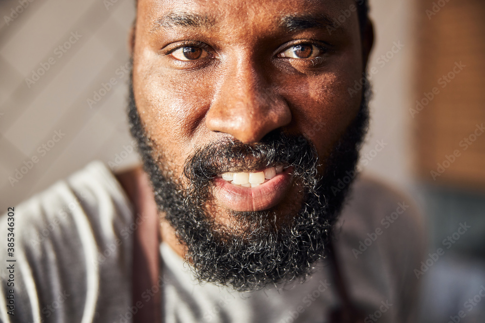 Obraz premium Smiling young bearded man cooking in cafe