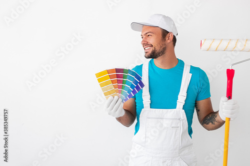Fototapeta Naklejka Na Ścianę i Meble -  Cheerful painter with roller and samples