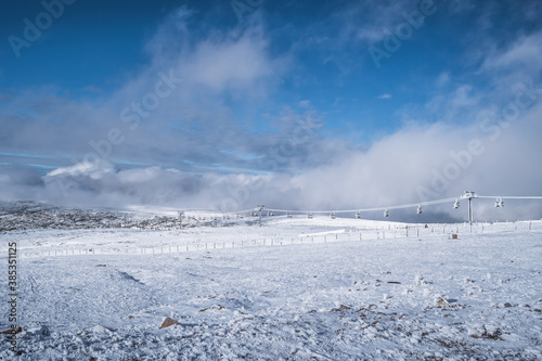 Mountain landscape with snow clouds and fog, frozen cable car, Serra da Estrela Natural Park - Manteigas PORTUGAL photo