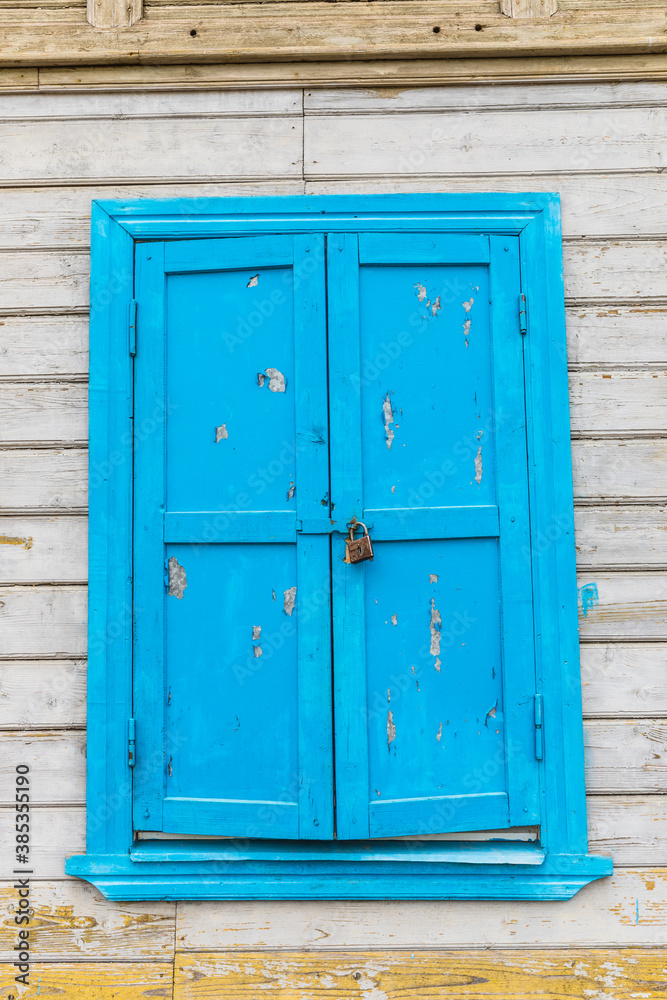 locked blue window on an old wooden house
