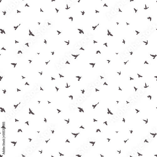 black birds silhouettes on white background; seamless pattern; flying flock doves in sky