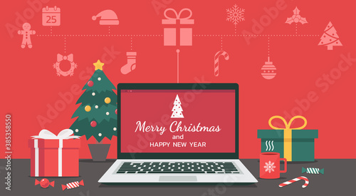 Merry Christmas and happy new year lettering on the laptop with Christmas icon and decorate with gifts, candy, cup, and Christmas tree on the desk, vector flat illustration