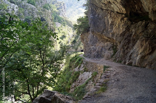 Trilha ao longo da parede rochosa em um vale na Ruta del Cares / Espanha photo