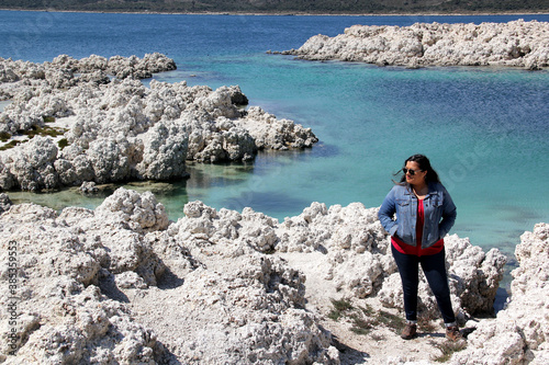 black hair latin woman in landscape of white rocks and water, turquoise blue lagoon. Alchichica Lagoon, Puebla Mexico photo